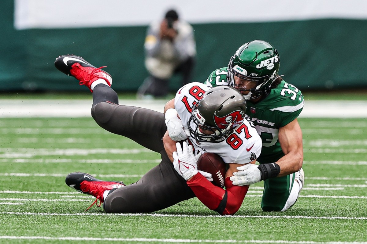 Jets safety Elijah Riley tackles Bucs tight end Rob Gronkowski